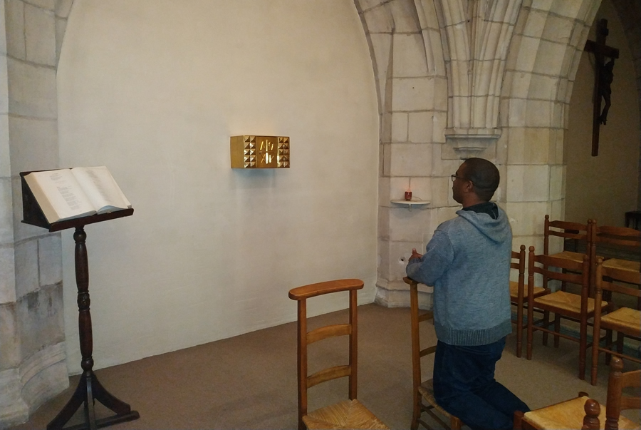séminariste à genoux priant à la chapelle